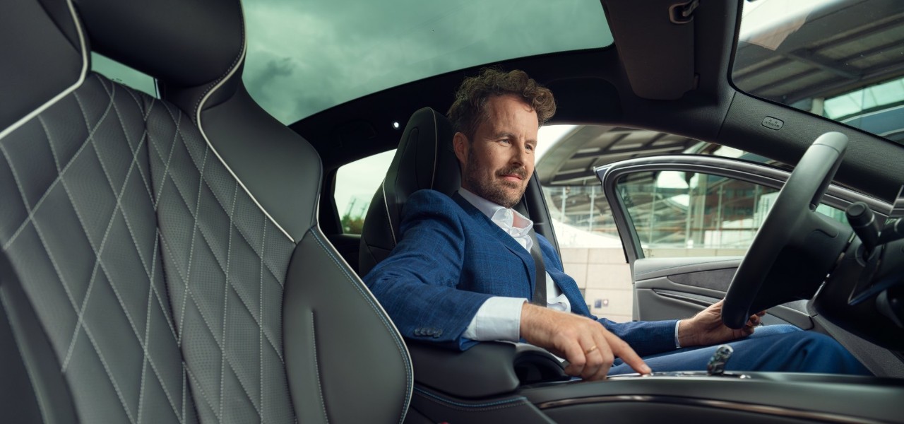 Man sitting in a car and playing with the board console