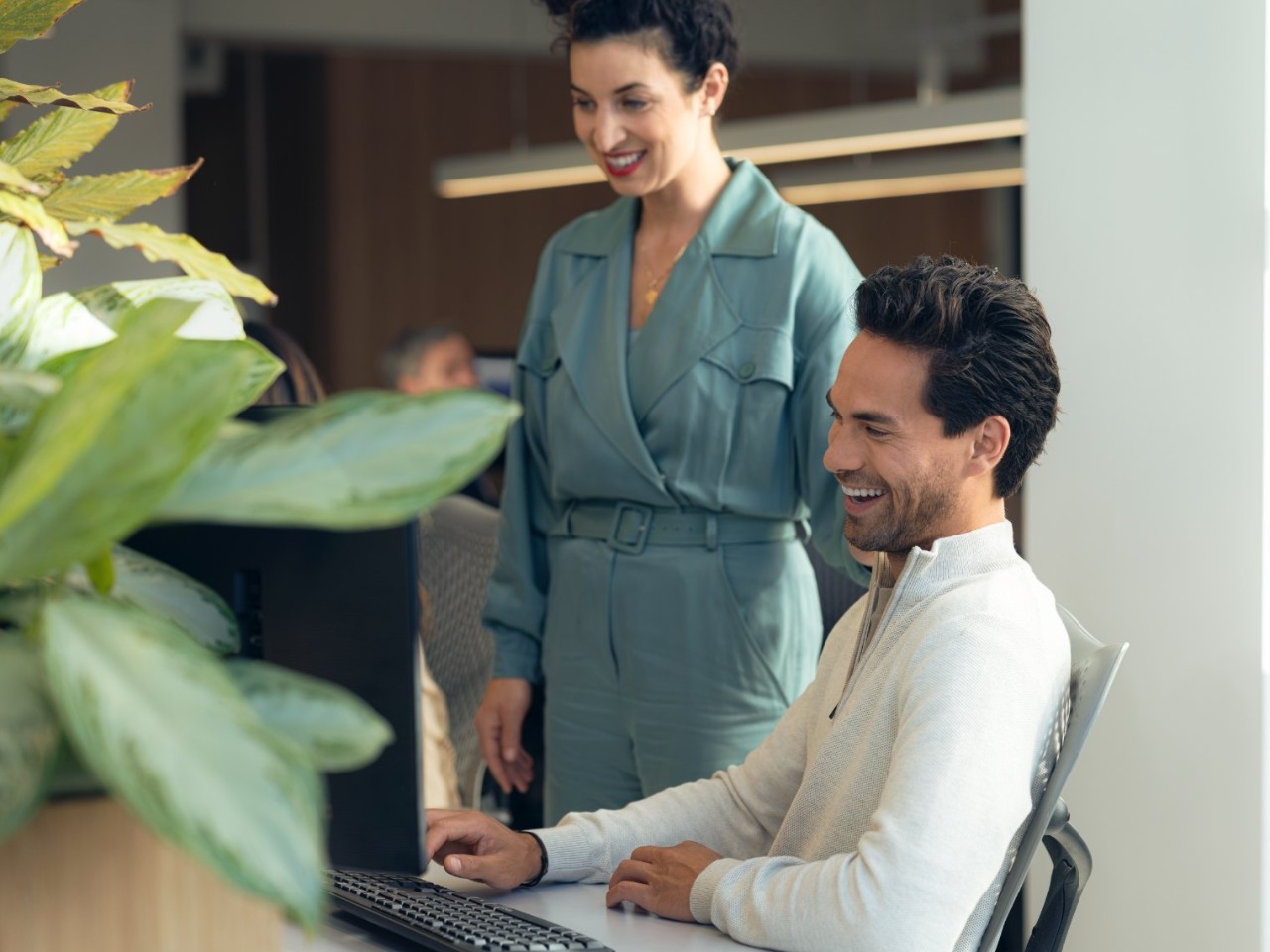 Man and woman looking at computer screen smiling. 