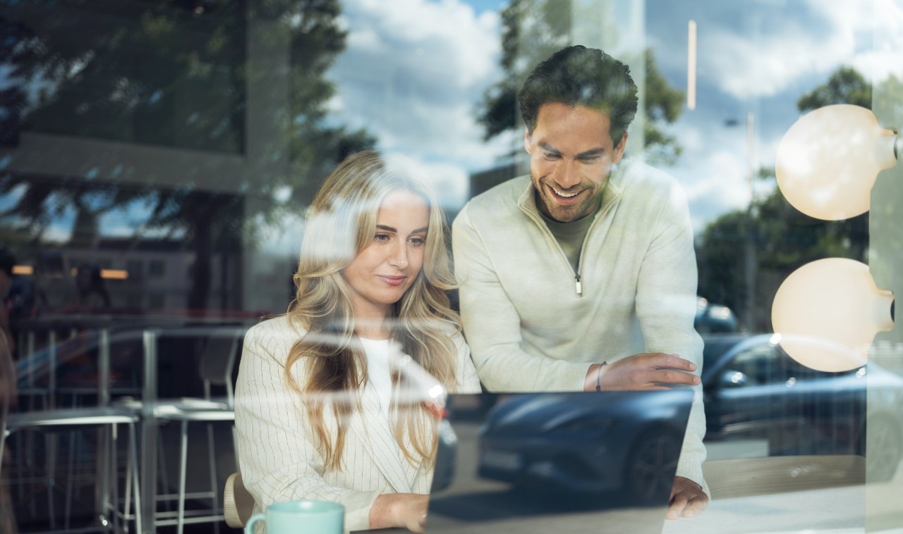 Two people in a café working on a laptop.